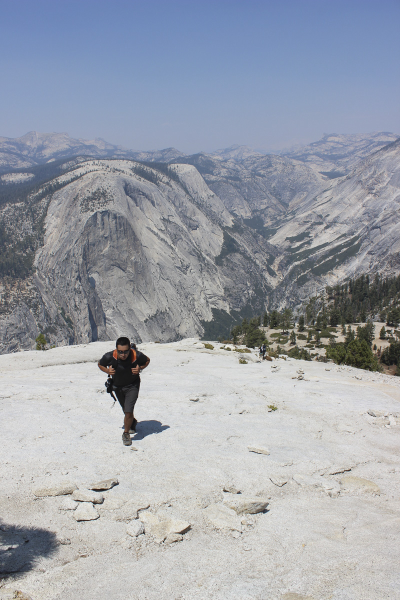 hombre caminando, en el fondo paisaje de montañas de granito de yosemite